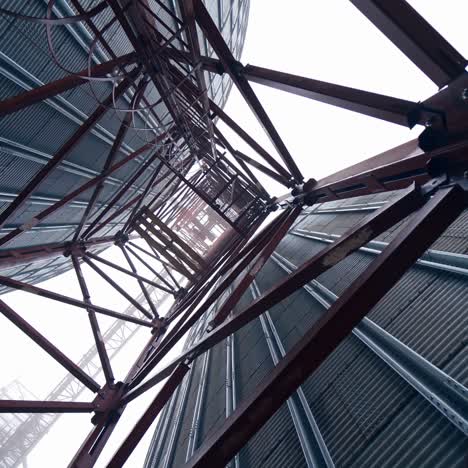 metal towers on industrial plant.. steel construction on a modern agricultural factory with grain elevators on sky background