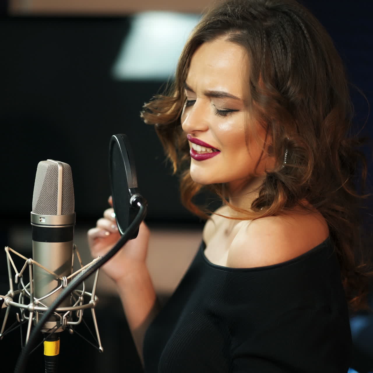 Giovane cantante donna registra un album in uno studio professionale. Donna che canta una canzone in uno studio di registrazione musicale. Video quadrato.