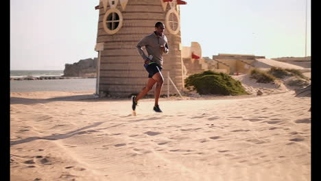 Corredor-Masculino-Afroamericano-Trotando-En-La-Playa-Bajo-El-Sol-4k