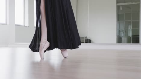 caucasian female ballet dancer practicing ballet during a dance class in a bright studio