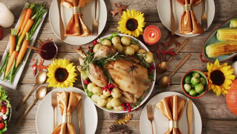 video of tray with roasted turkey, diverse dishes and autumn decoration on wooden surface