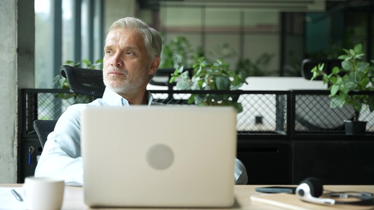Mature Businessman Working on Laptop in Modern Office