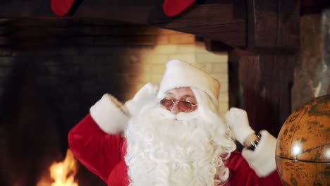 tired santa yawning and stretching indoors. portrait of santa claus with white beard in glasses sitting near fire place wants to sleep after working at night before christmas
