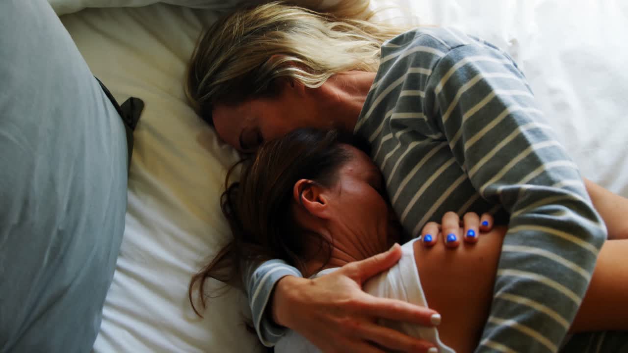 Lesbian couple relaxing on bed in bedroom 4k