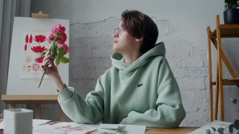 young artist smelling a bouquet of roses in a cozy studio