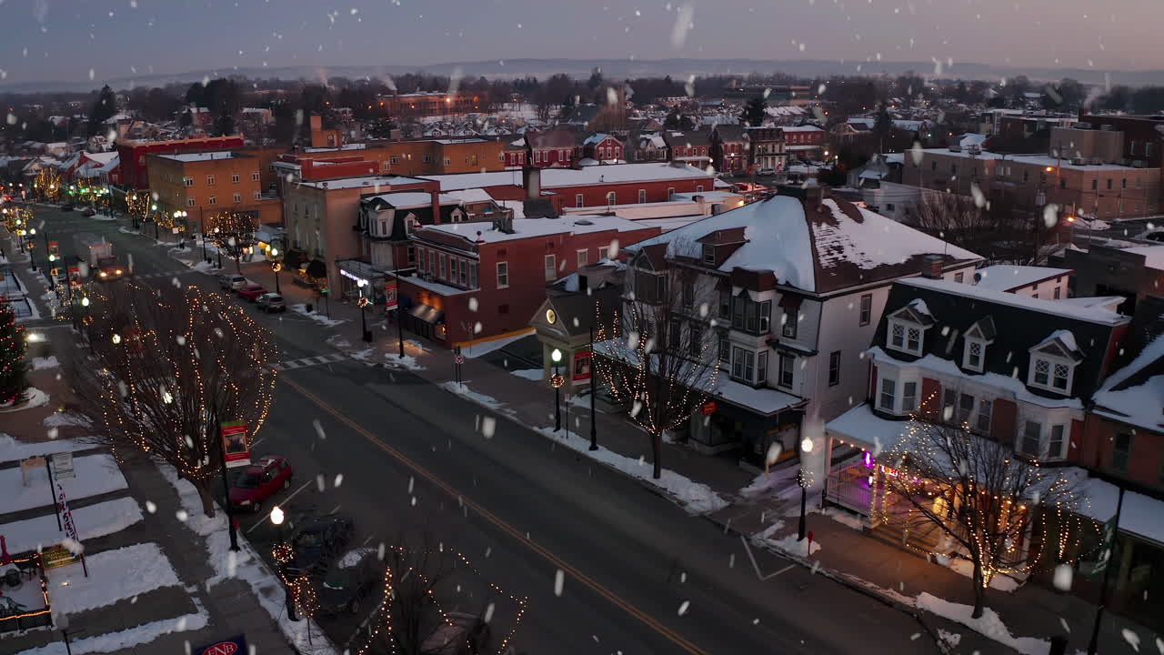 copos de nieve caen sobre casas victorianas en navidad