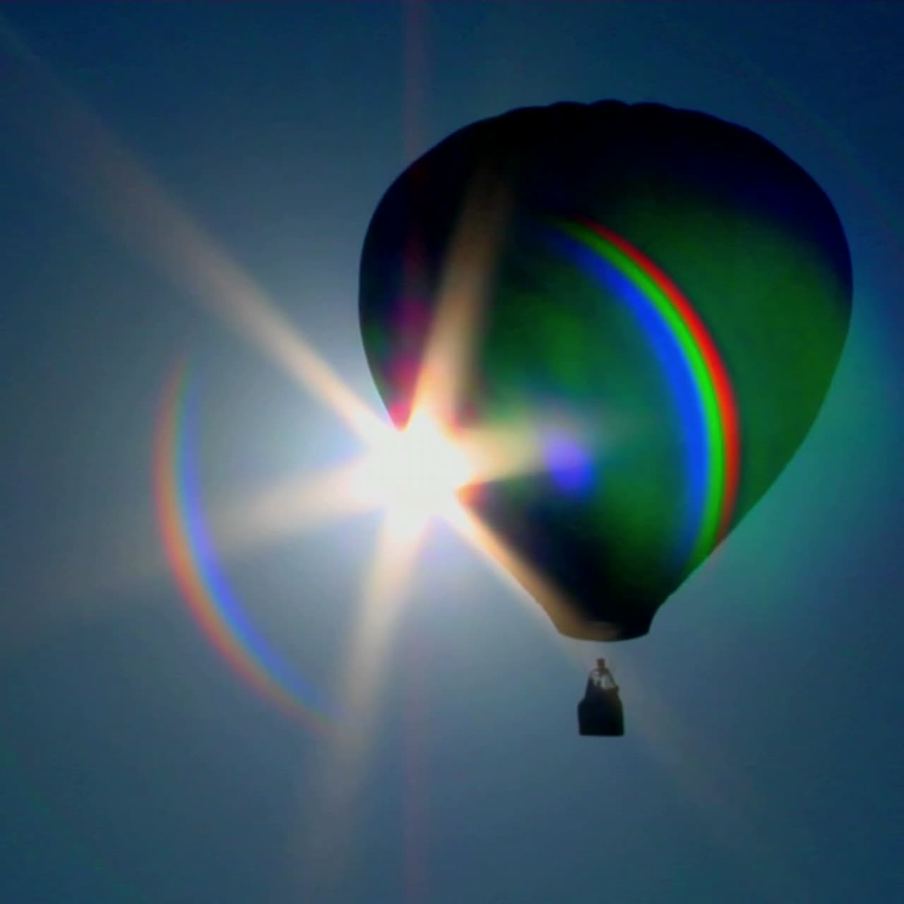 un globo aerostático cruza contra el sol