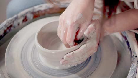 pottery artist shaping a bowl on a wheel