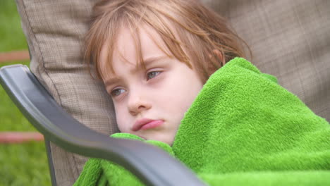 tired child wrapped up in a towel after swimming