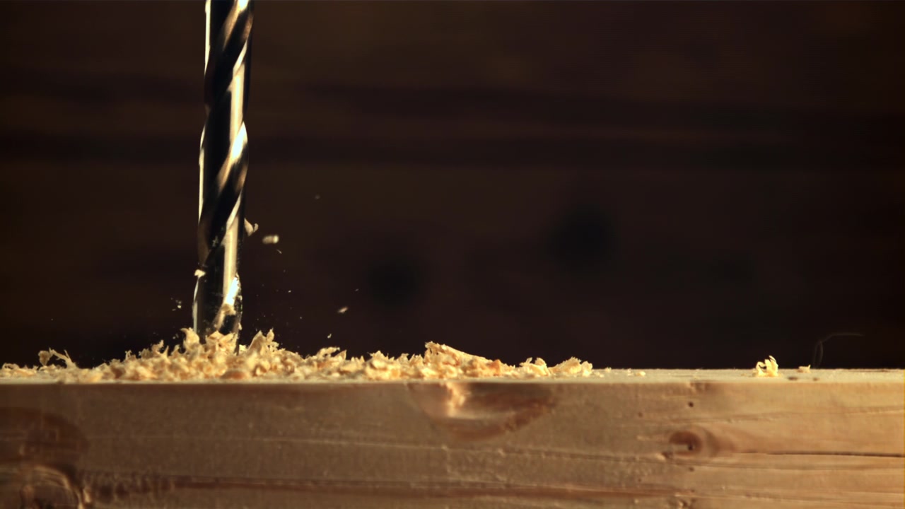 Slow Motion Close-up of a Drill Bit Drilling into Wood