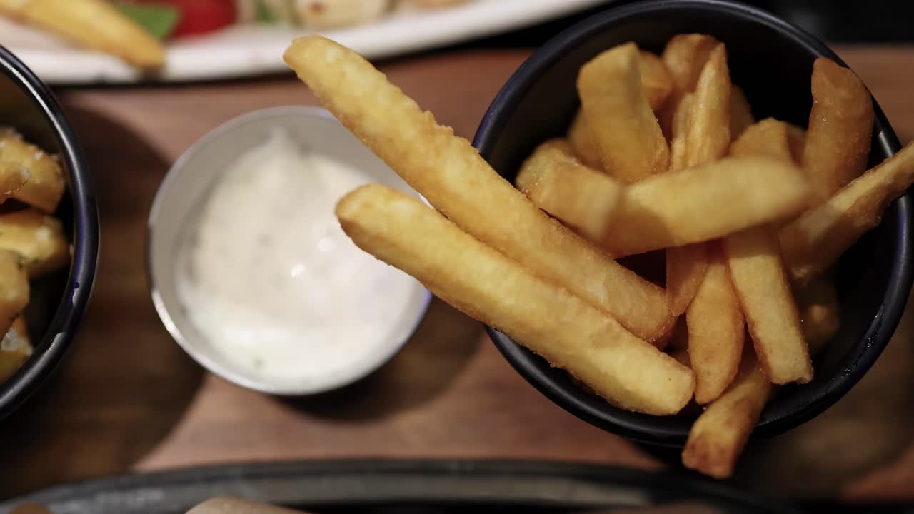Batatas fritas e asas de frango com molhos para acompanhar