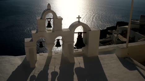 close up of four church bells at sunset at oia, santorini