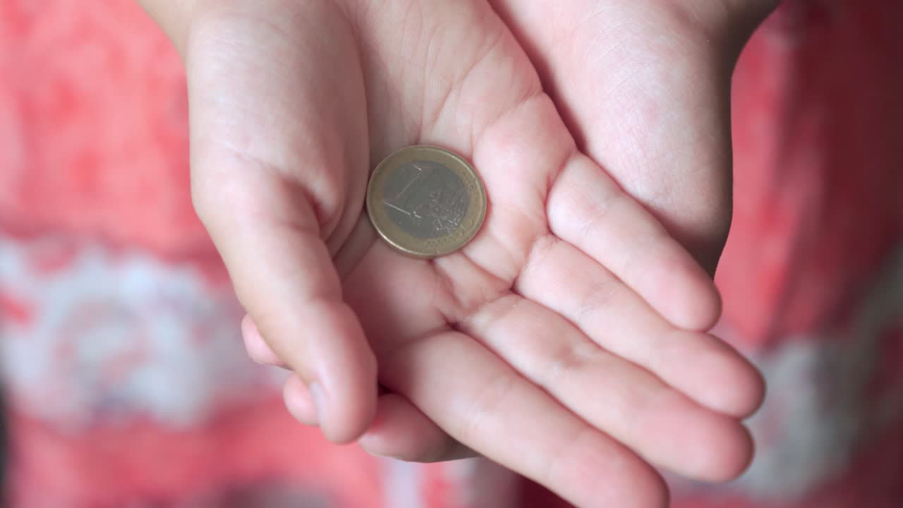 la moneda es un euro en manos de los niños.