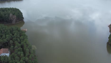 Vista-Aérea-De-Drones-De-Una-Presa-De-Tamaño-Mediano-Y-Un-Embalse-En-Un-Día-Nublado-Sobre-Agua-De-Espejo,-En-Castellon,-España