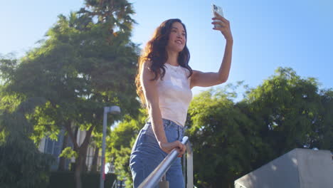 Fröhliche-Frau,-Die-Treppen-Steigt-Und-Einen-Fotopark-Macht.-Asiatische-Dame-Benutzt-Smartphone.