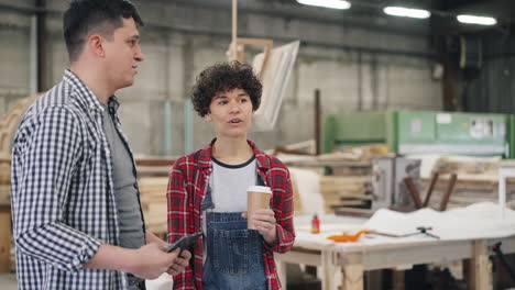 two colleagues discussing in a woodworking workshop