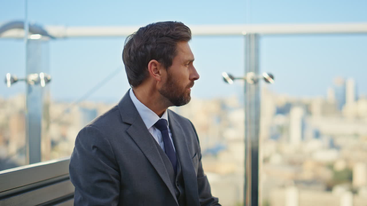 gerente disfrutando del café de la mañana en la terraza del café de vidrio. hombre barbudo comprobando la celda