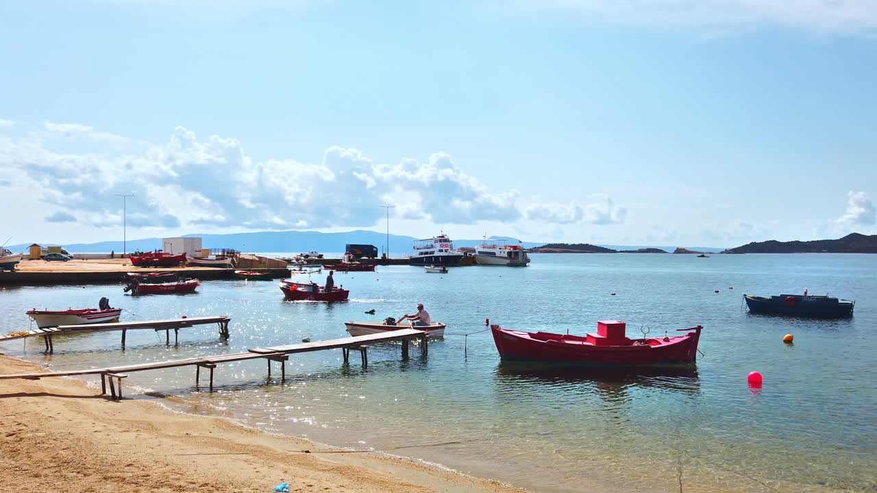 Ege Denizi'nde çok sayıda bağlı ve hareket halindeki tekne, arka planda tepeler, Uranopolis, Yunanistan'da deniz limanı