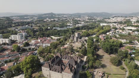 Church-of-Sao-Miguel-do-Castelo,-Palace-of-the-Dukes-of-Braganza-and-Castle,-aerial-orbital-shot-in-Guimaraes-Portugal