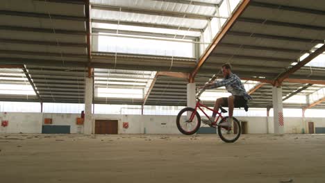 bmx riders in an empty warehouse