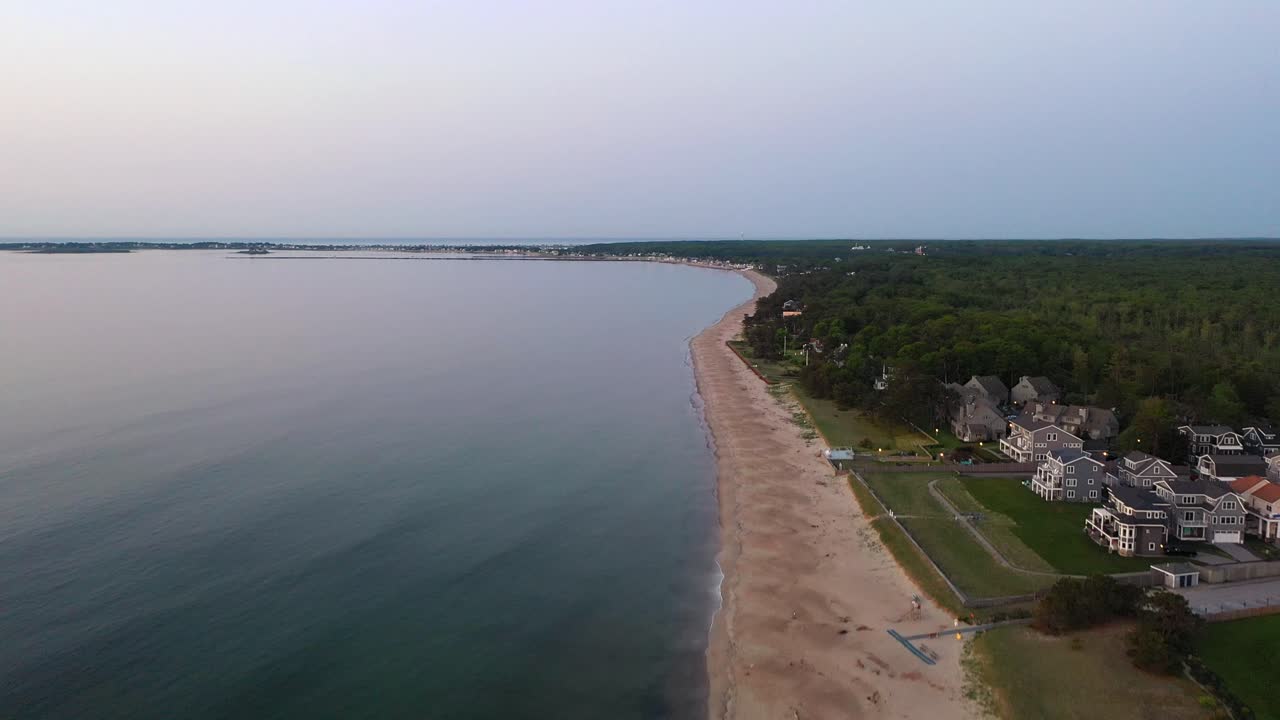Video aereo con drone di spiagge a Saco, Maine, durante la bassa stagione, senza persone sulla sabbia vuota accanto a case vacanza e le onde dell'Oceano Atlantico che colpiscono la costa