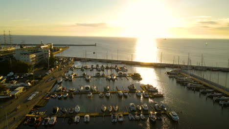 Golden-Sunset-Reflecting-On-The-Calm-Waters-Of-Baltic-Sea-Seen-From-The-Marina-Gdynia-With-Moored-Sailboats-In-Gdynia,-Poland