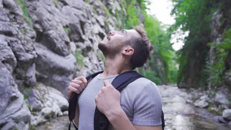 the man standing in the canyon looks around.