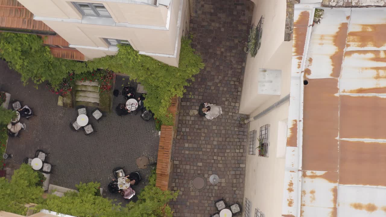 A Bride and Groom Pose for a Wedding Photo in a City Courtyard