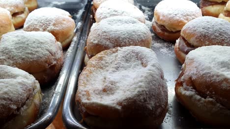 brazilian berliner with custard filling being displayed at a brazilian bakery showcase_side tracking.