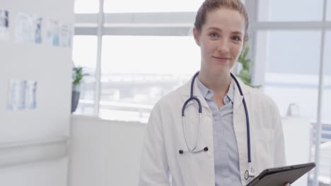 Portrait-of-happy-female-doctor-using-tablet-and-smiling-in-hospital,-in-slow-motion