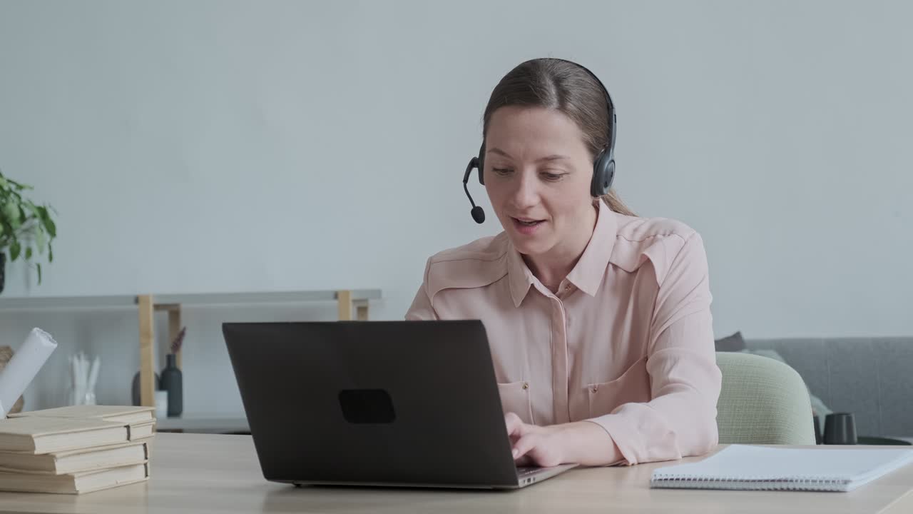 Happy woman in headphones looking at camera, enjoying video meeting with friends and colleagues