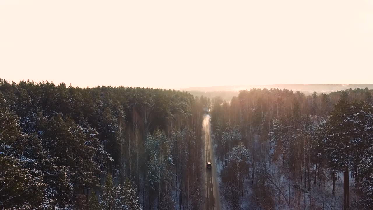 carretera forestal nevada con vehículo al amanecer o al atardecer
