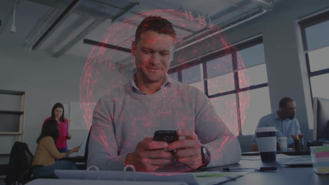 Kontoransatt bytter fra smarttelefon til bærbar PC etter varsel, med rødt holografisk nett som markerer papirer.