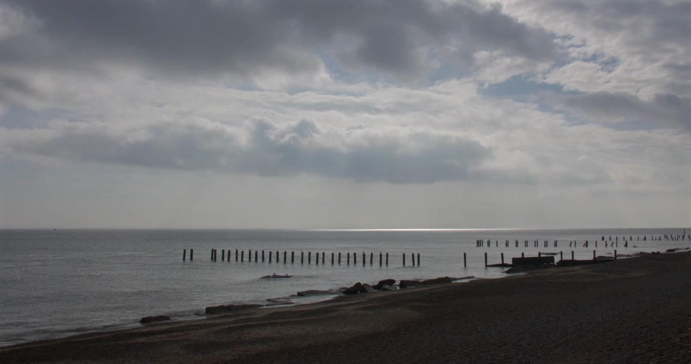 Inquadratura extra larga accelerata che guarda a sud lungo la spiaggia di Corton con pennelli frangiflutti rotti a Lowestoft
