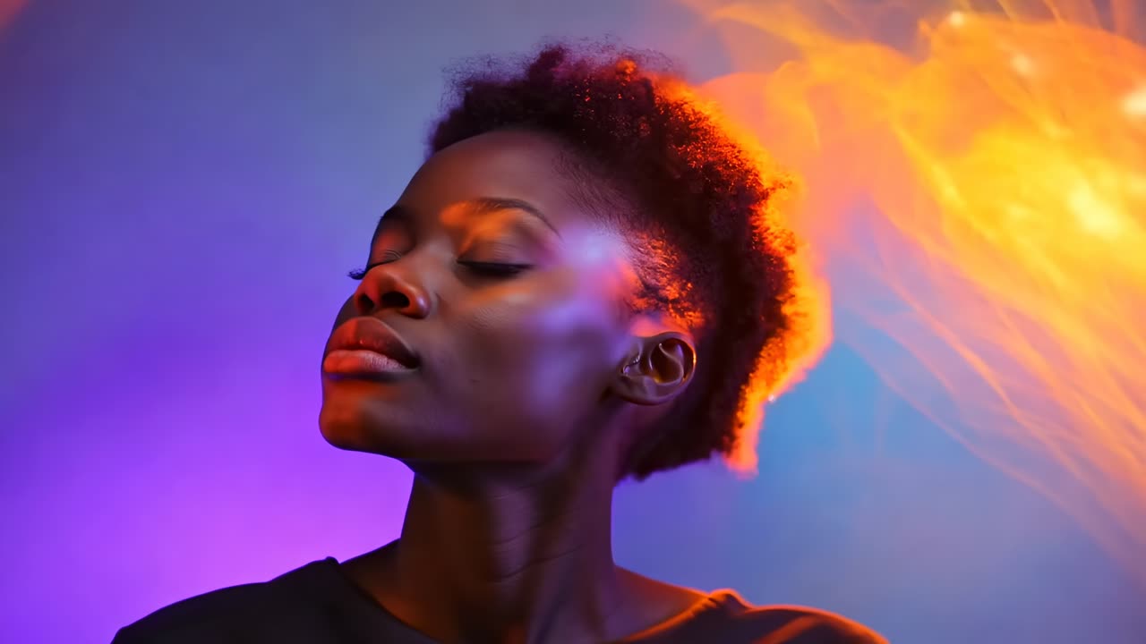 Video di un primo piano con espressione serena, illuminazione viola e arancione vivace e una parte laterale