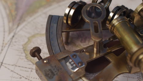 un sextand náutico de latón antiguo en un mapa vintage del mundo