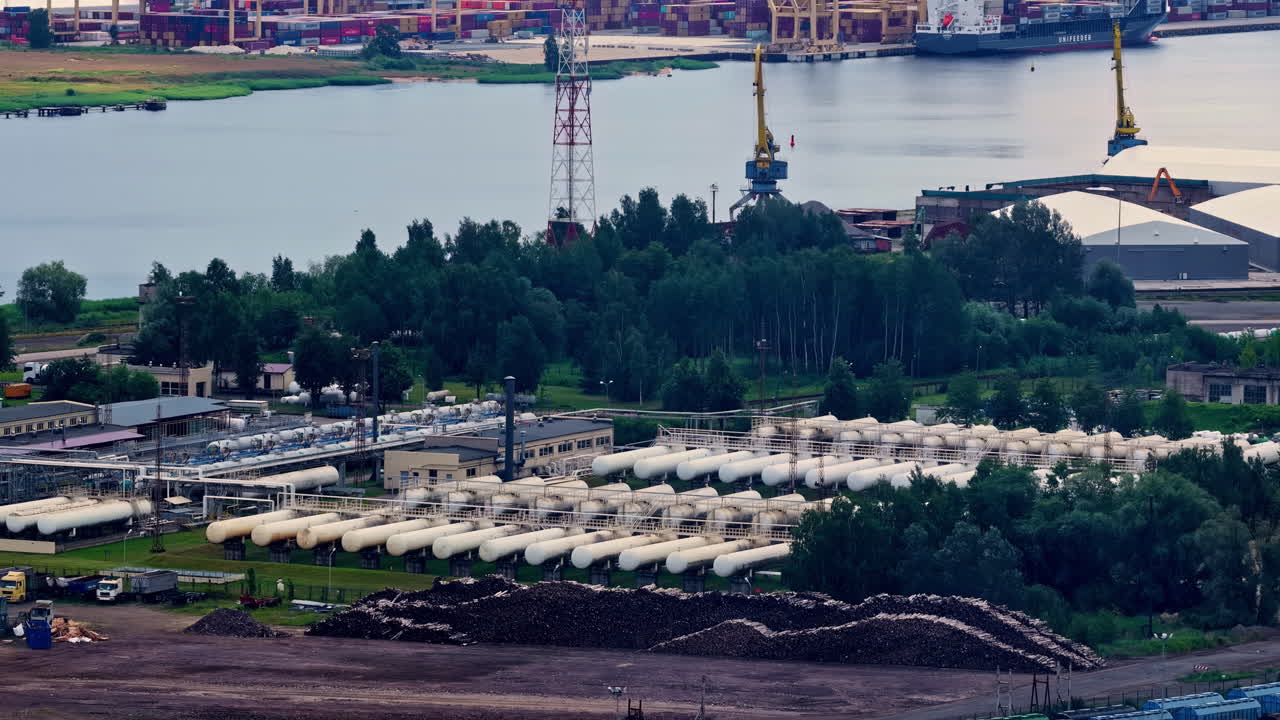 Gas storage facility near river port surrounded by trees