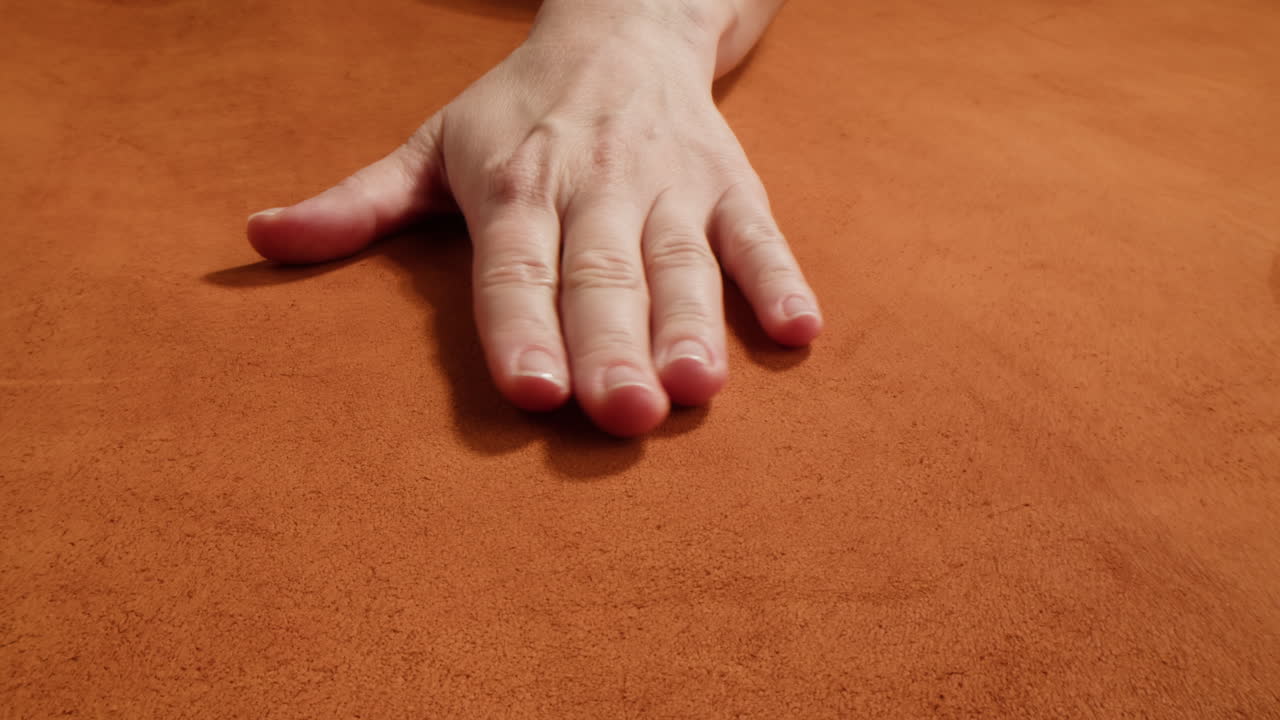 Mano su tessuto arancione