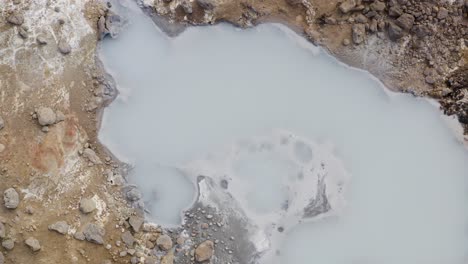 aerial overview shot of hot geothermal mud pot in iceland