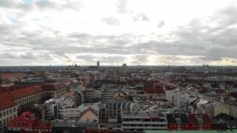 Tomas-Aéreas-De-Munich-Alemania-Por-La-Tarde-Mirando-Hacia-El-Suroeste-Con-Una-Puesta-De-Sol-Y-Nubes-Para-Un-Efecto-Dramático