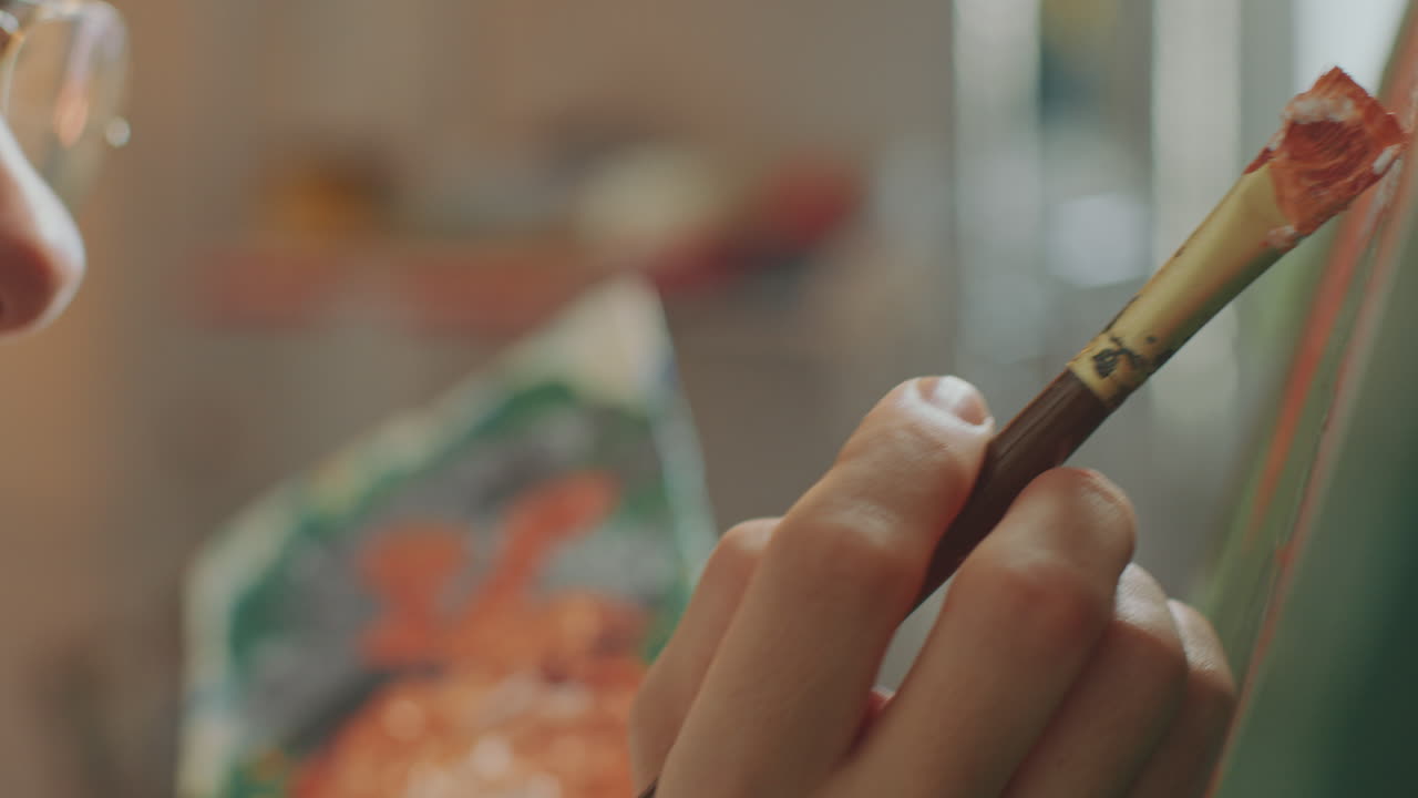 artista enfocado aplicando pinceladas al lienzo en el estudio