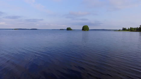 Drone-taking-off-forward-on-a-calm-lake-in-Finland