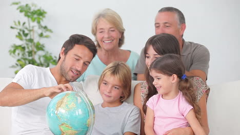 multigeneration family all looking at globe