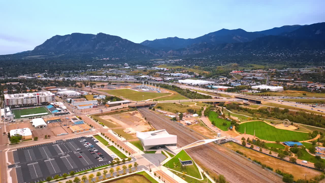 Low-rise cityscape of Colorado Springs, Colorado, USA outlined by the mountain range. Drone footage over the city with heavy traffic on roads