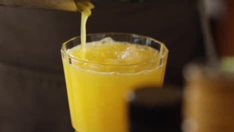 Slow-motion-shot-of-bartender-preparing-an-orange-juice-cocktail-beverage