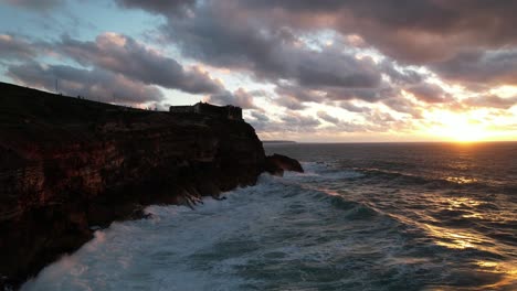 dramatic sunset over ocean cliffs with crashing waves