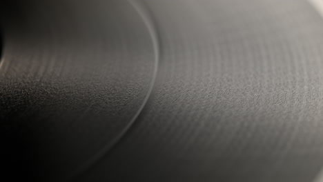 spinning vinyl record - camera slides from the record label to its outer edge, over the wooden table