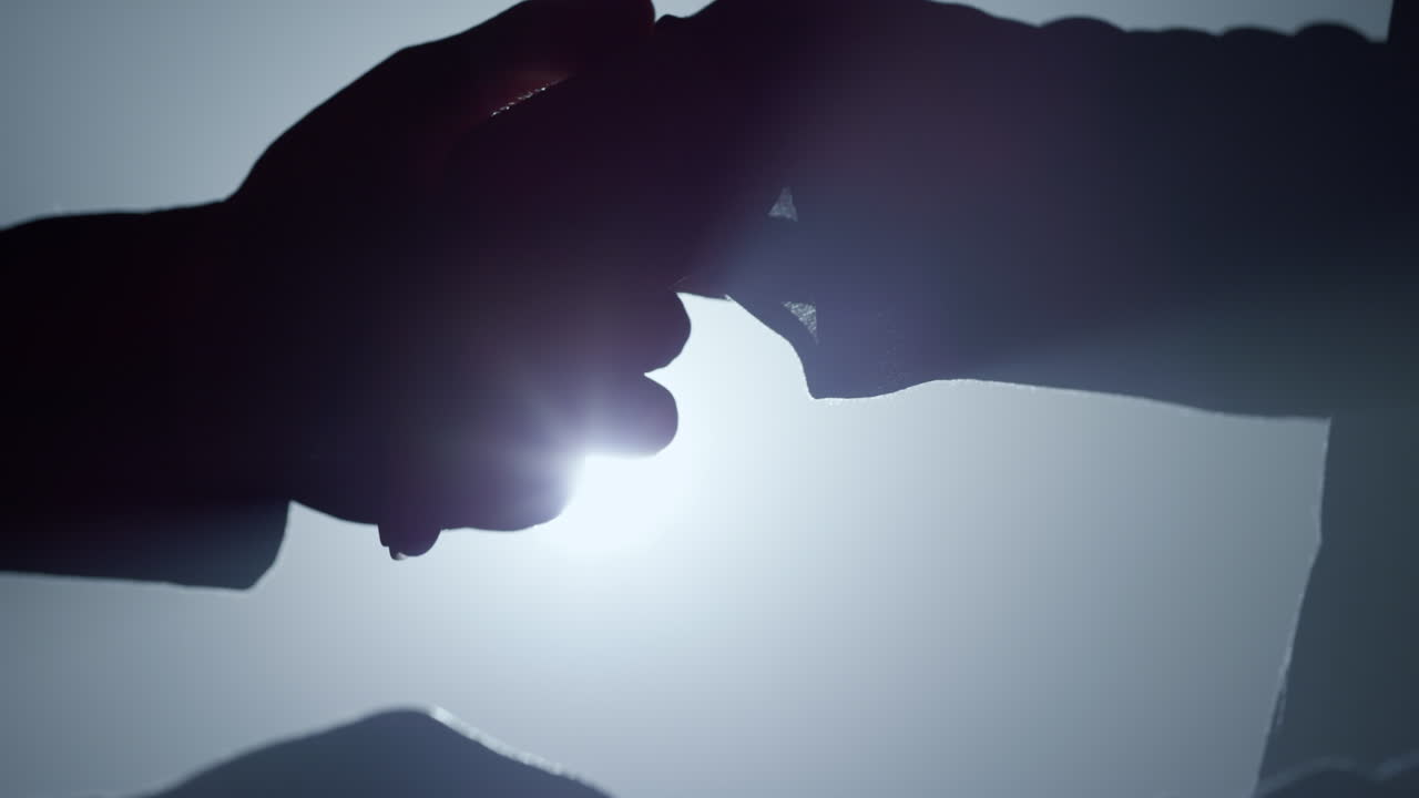 Silhouette romantic couple holding hands indoors. Relationship concept.