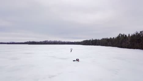 Get-an-aerial-view-of-Ice-Fishing-on-Fitzgerald-Pond,-Maine