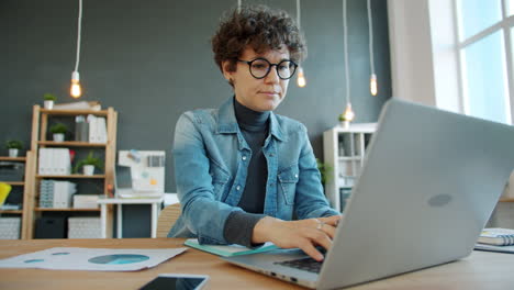 mujer trabajando en una computadora portátil en una oficina moderna